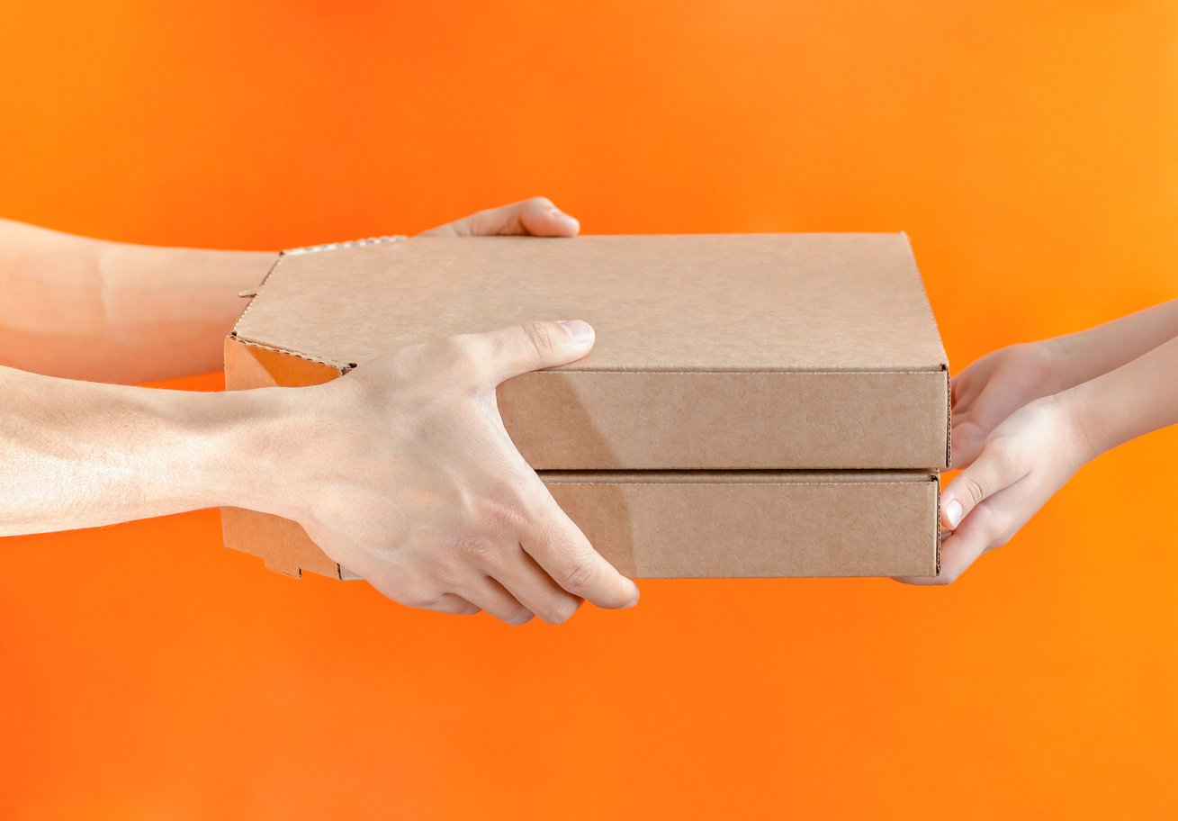 Delivery man giving two boxes with pizza to boy. Delivery concept.