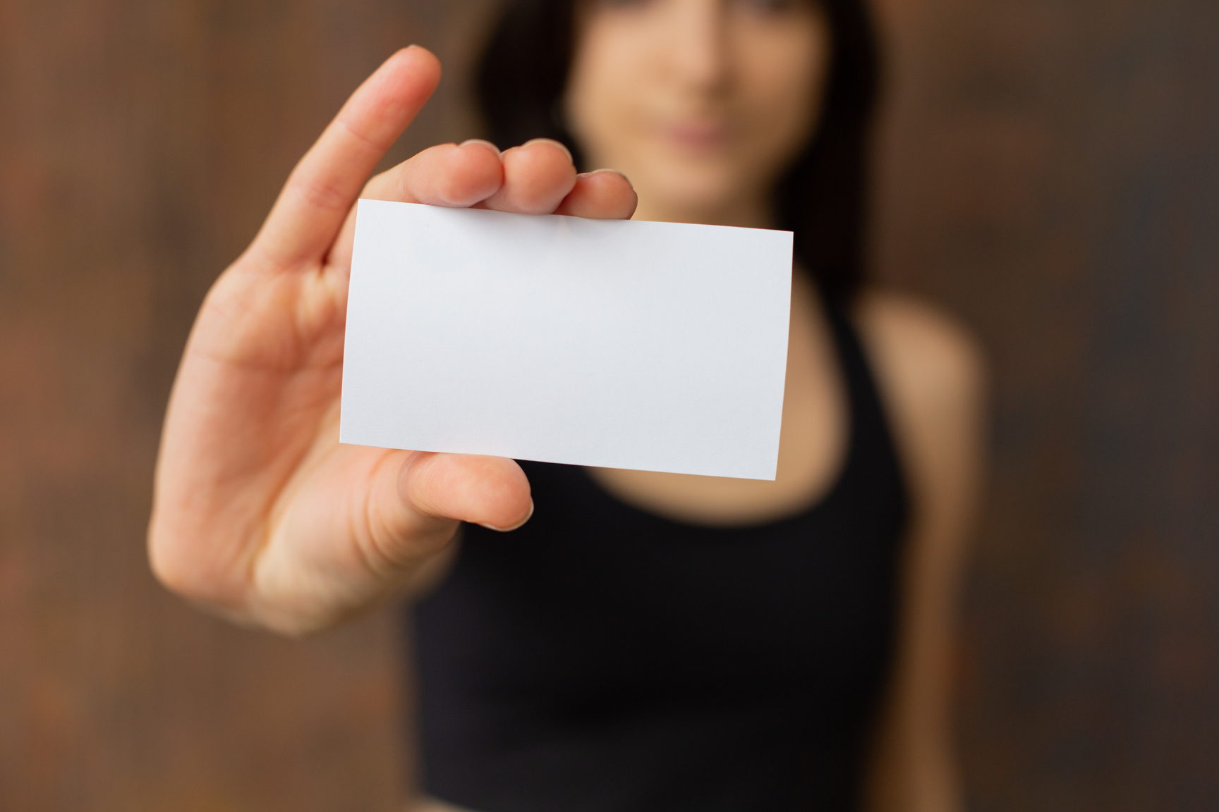 Crop woman showing blank business card